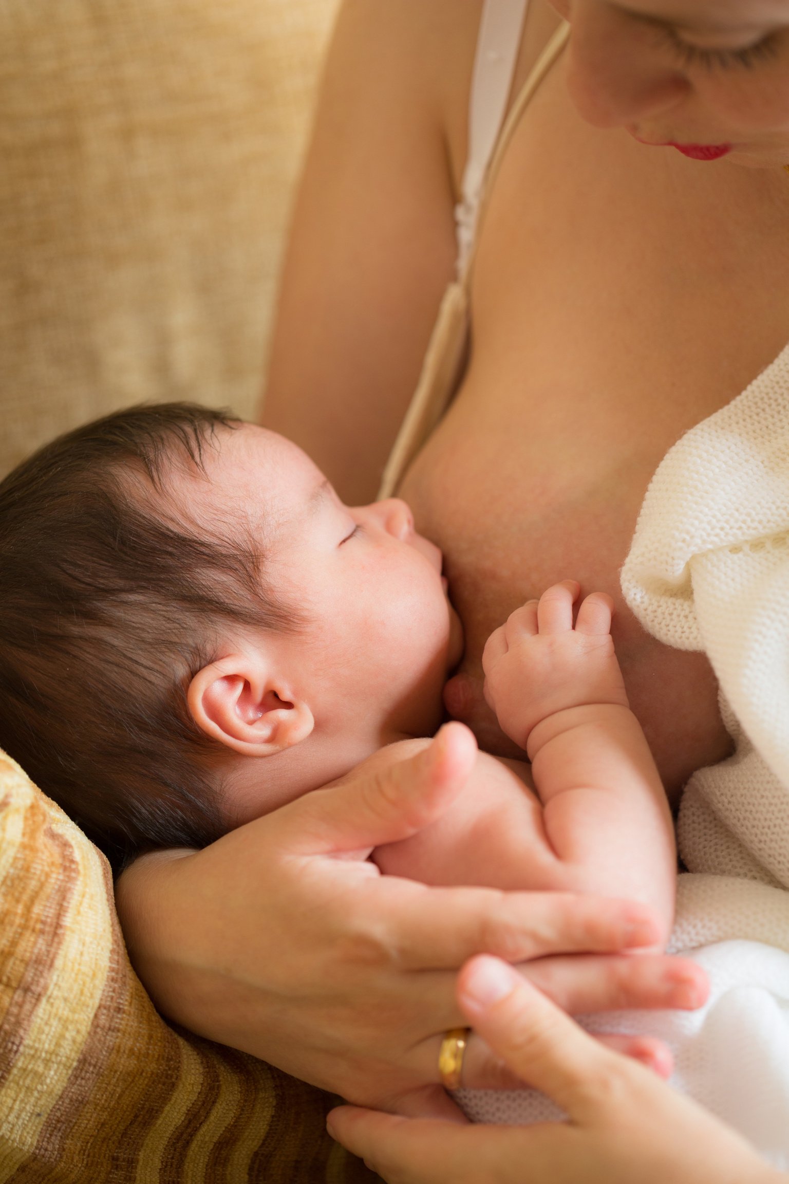 young woman breastfeeding her newborn baby